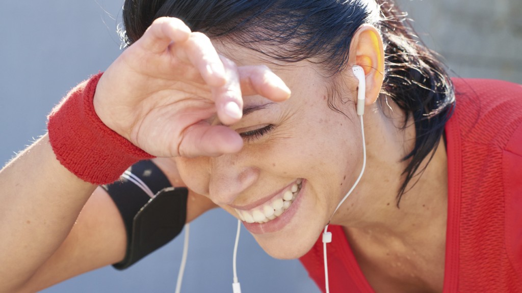Young woman laughing and wiping away her sweat after jogging workout