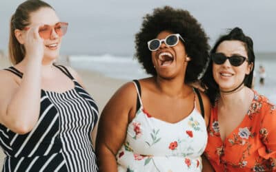 Cheerful group of women laughing and smiling at the beach