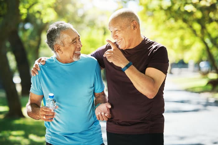 Two people smiling and laughing while walking together outside