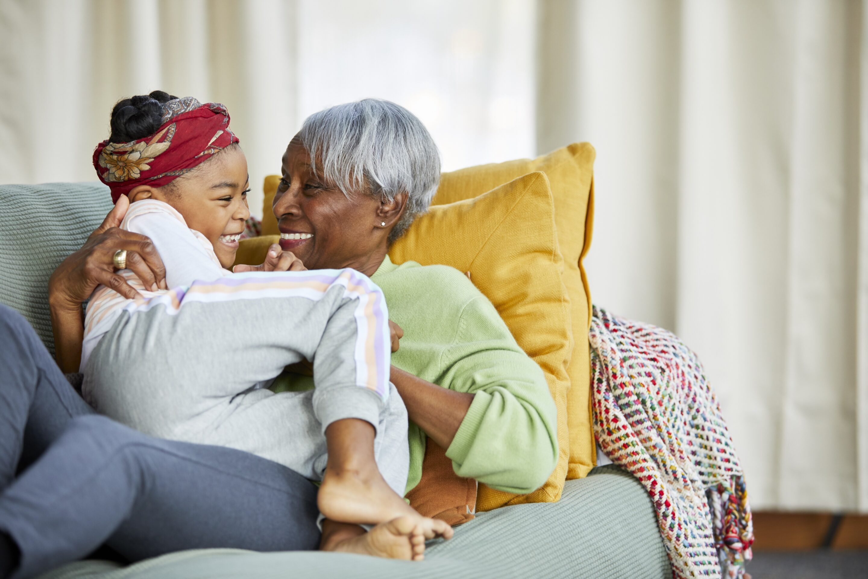 Grandmother and granddaugther snuggling on the couch
